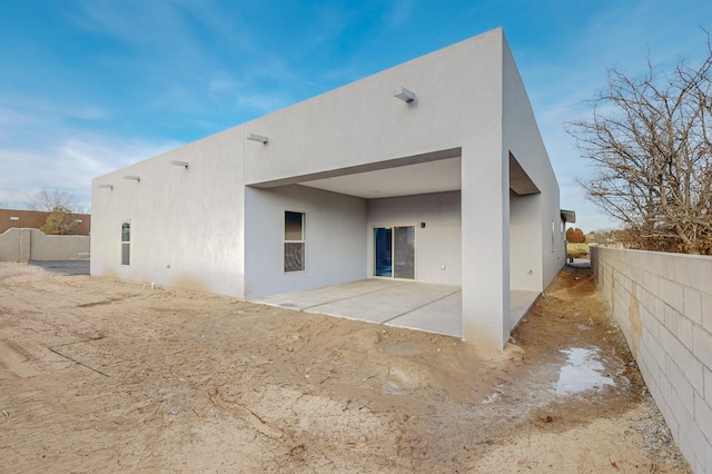 back of house featuring a patio area, stucco siding, and fence