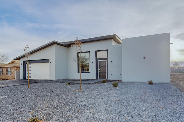 modern home with concrete driveway, a garage, and stucco siding