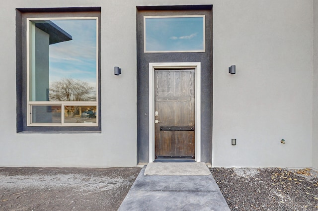 entrance to property featuring stucco siding