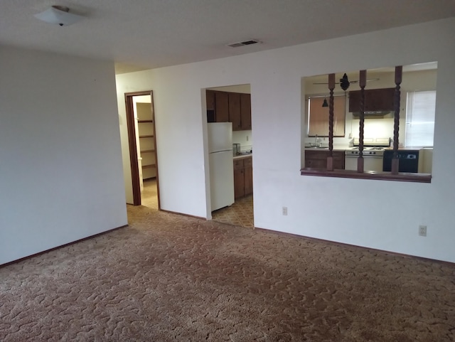 unfurnished room featuring sink and light colored carpet