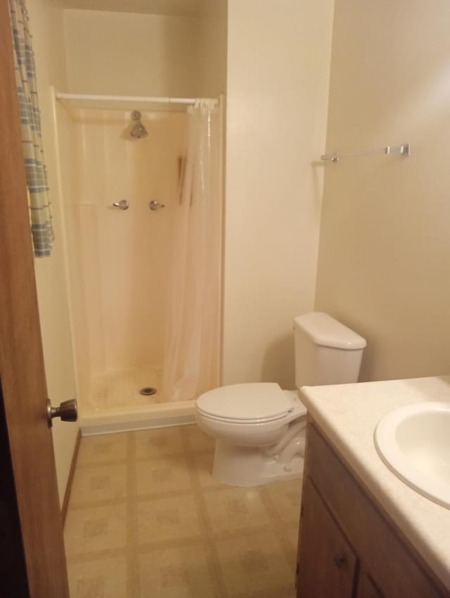 bathroom with toilet, vanity, and a shower with curtain