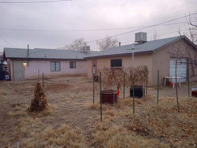 back of house with central AC unit