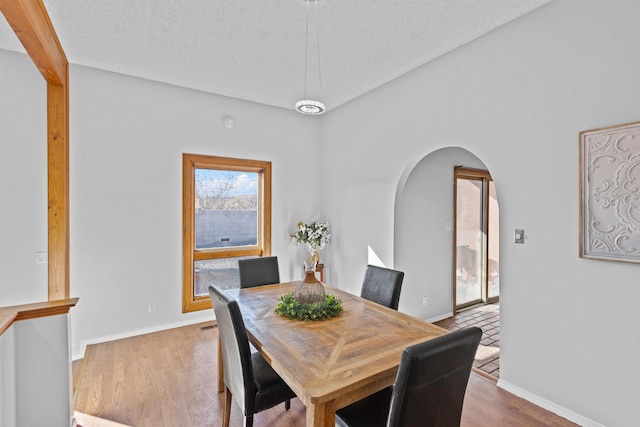 dining area featuring light hardwood / wood-style floors and a textured ceiling