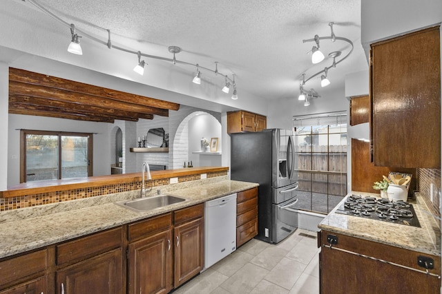 kitchen featuring light tile patterned floors, a textured ceiling, stainless steel appliances, and sink