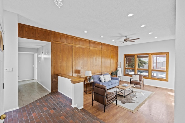 living room featuring ceiling fan and a textured ceiling