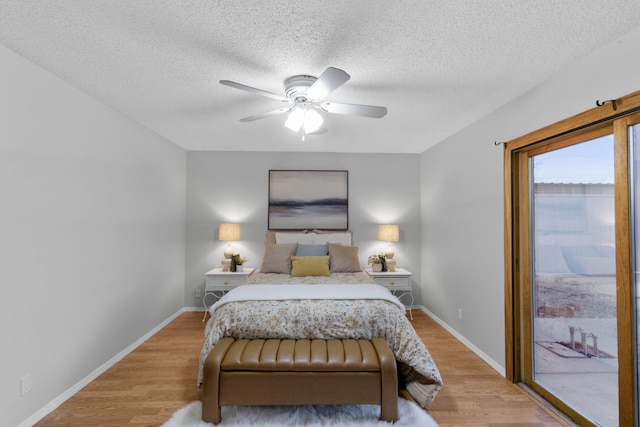 bedroom with access to outside, ceiling fan, light hardwood / wood-style flooring, and a textured ceiling