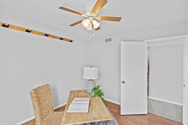 office space with ceiling fan, a textured ceiling, and hardwood / wood-style flooring