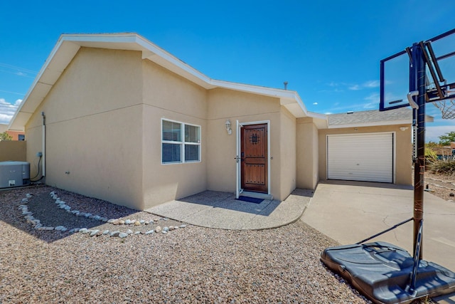 view of front of house with a garage and central air condition unit