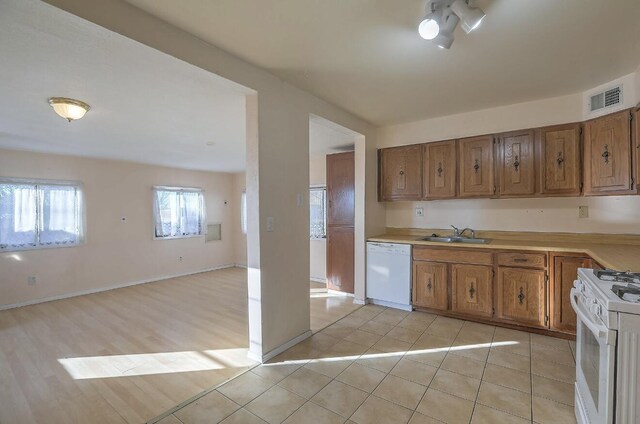 kitchen with sink, white appliances, and light tile patterned flooring