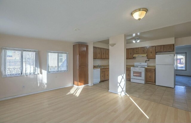 kitchen featuring white appliances, light hardwood / wood-style flooring, and sink