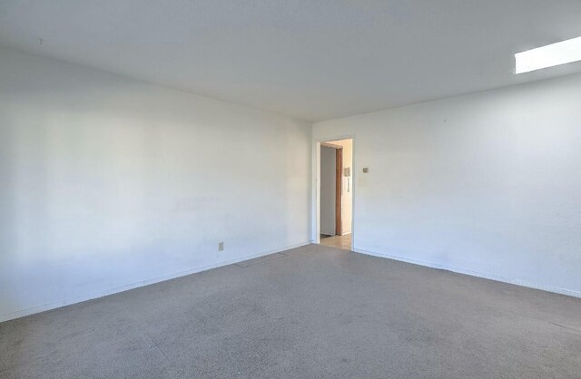 unfurnished room with a skylight