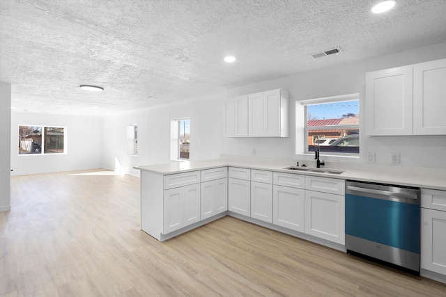 kitchen featuring white cabinets, dishwasher, sink, kitchen peninsula, and light hardwood / wood-style flooring