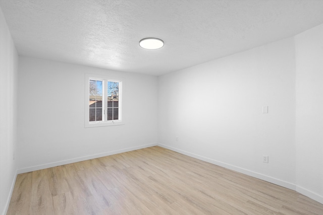 empty room featuring a textured ceiling and light wood-type flooring