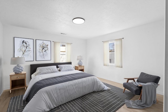 bedroom with wood-type flooring and a textured ceiling