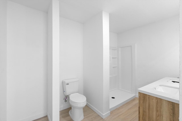 bathroom with toilet, vanity, wood-type flooring, and walk in shower