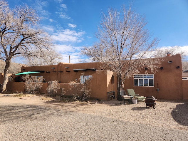 back of property featuring an outdoor fire pit