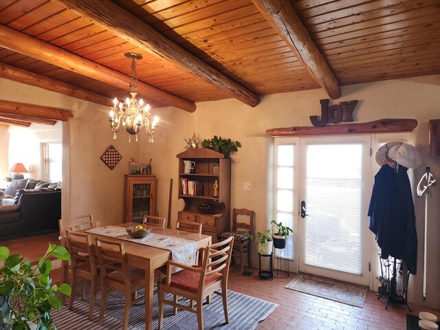 dining area with wooden ceiling, an inviting chandelier, and beam ceiling