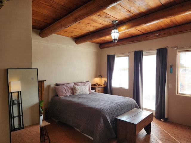 bedroom with wooden ceiling, multiple windows, brick floor, and beam ceiling