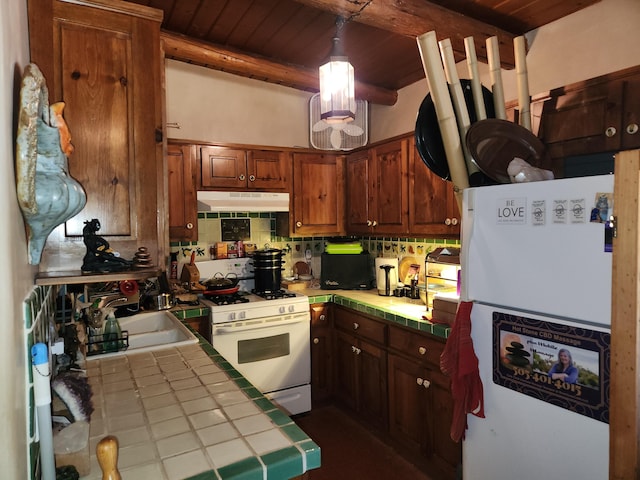 kitchen featuring white appliances, decorative light fixtures, tile countertops, wooden ceiling, and beam ceiling