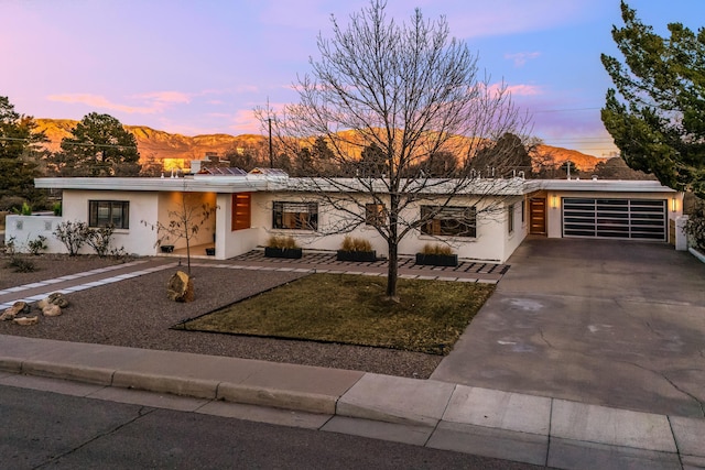 single story home featuring a garage and a mountain view