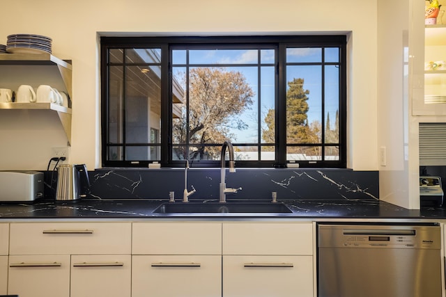 kitchen featuring white cabinets, dishwasher, dark stone countertops, and sink