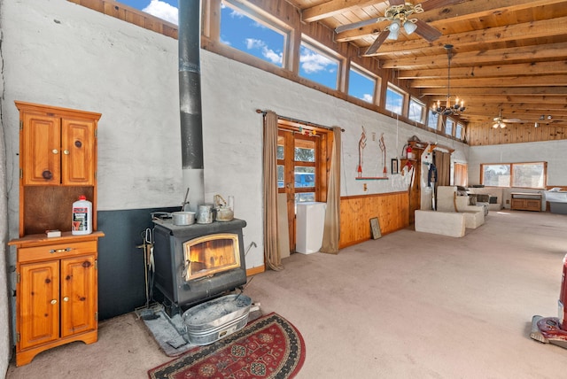 living room with a healthy amount of sunlight, a wood stove, wooden ceiling, and ceiling fan