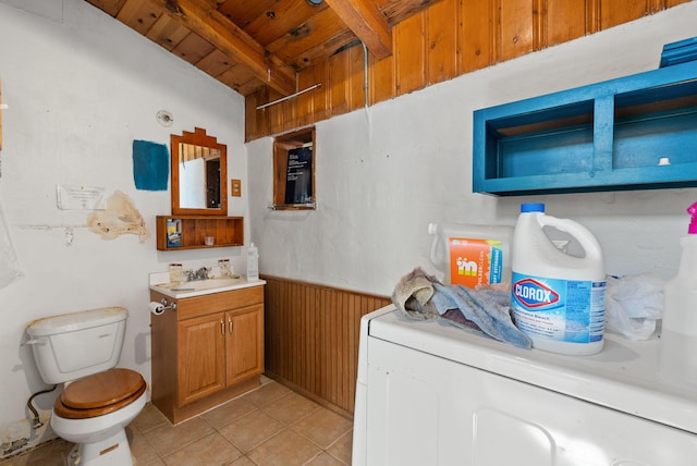 washroom featuring washer / clothes dryer, wood ceiling, wooden walls, and sink