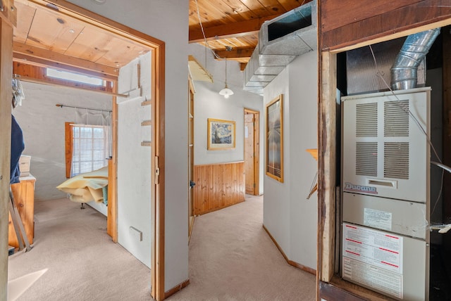 hallway featuring wood ceiling, light colored carpet, beam ceiling, and wood walls