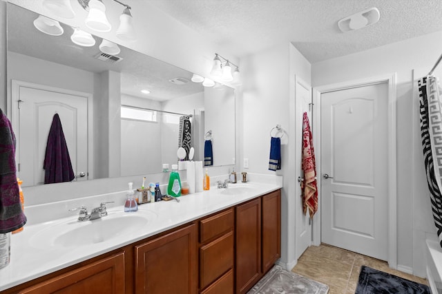 bathroom featuring a textured ceiling, shower / bath combination with curtain, and vanity