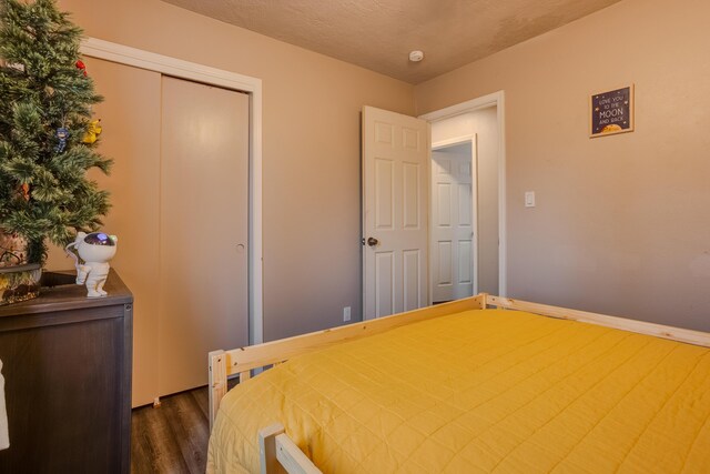 bedroom featuring a textured ceiling, ceiling fan, and dark hardwood / wood-style floors