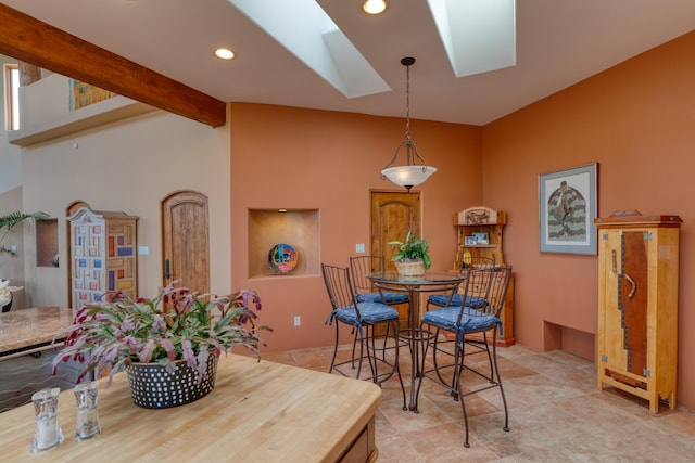 dining area with a skylight and beamed ceiling