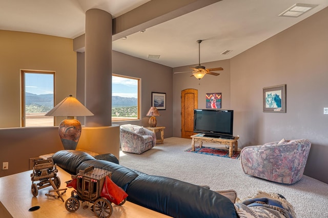 living room with carpet floors, ceiling fan, a wealth of natural light, and a mountain view