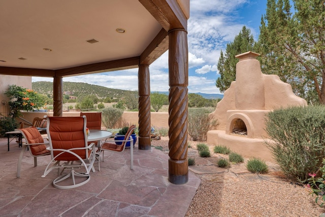 view of patio with a mountain view and exterior fireplace