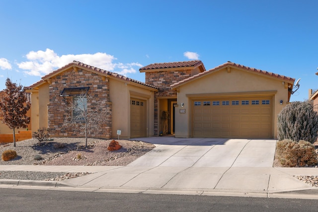 view of front of property with stucco siding, concrete driveway, a garage, stone siding, and a tiled roof