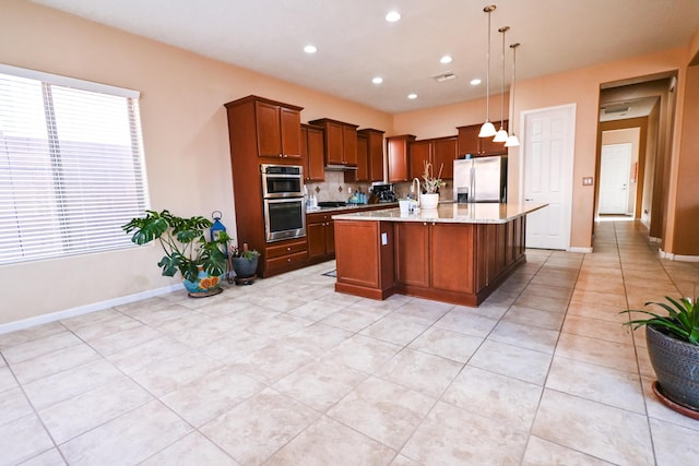 kitchen with recessed lighting, stainless steel appliances, visible vents, baseboards, and an island with sink