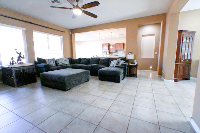 living room with ceiling fan, visible vents, baseboards, and light tile patterned flooring