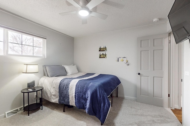 carpeted bedroom featuring a textured ceiling, ceiling fan, and crown molding