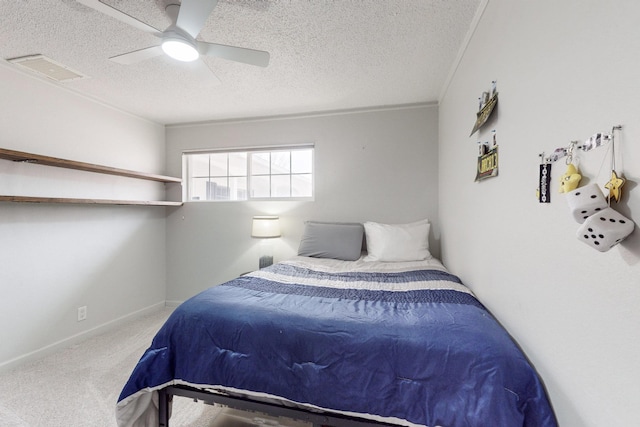 bedroom featuring ceiling fan, a textured ceiling, crown molding, and carpet floors