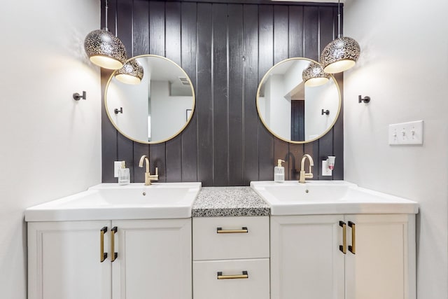 bathroom with vanity and wood walls