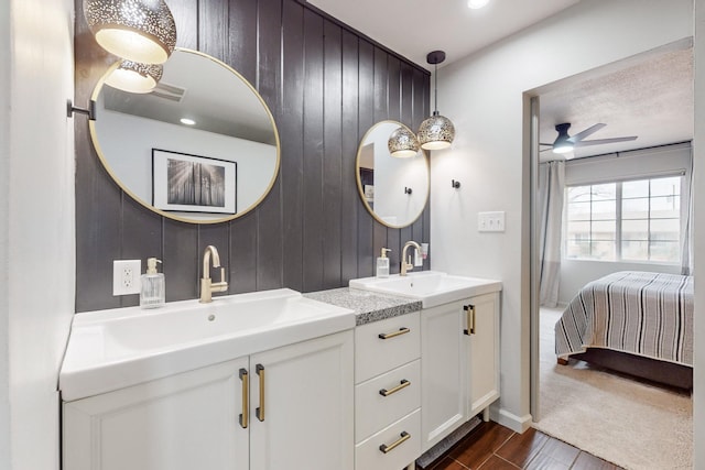 bathroom featuring ceiling fan, wood walls, and vanity