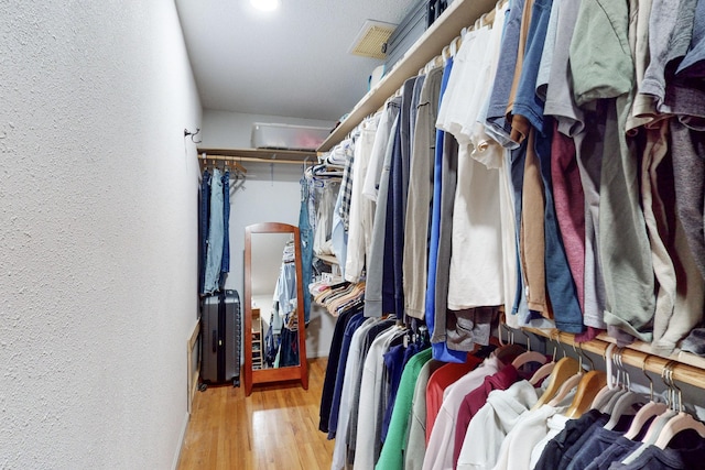 walk in closet with light hardwood / wood-style flooring