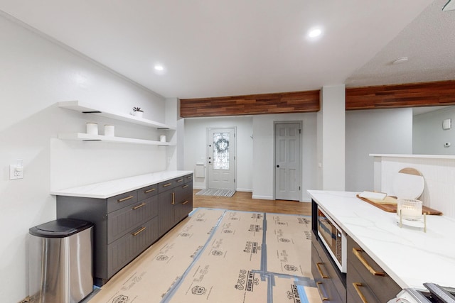 kitchen with light stone counters and light hardwood / wood-style flooring