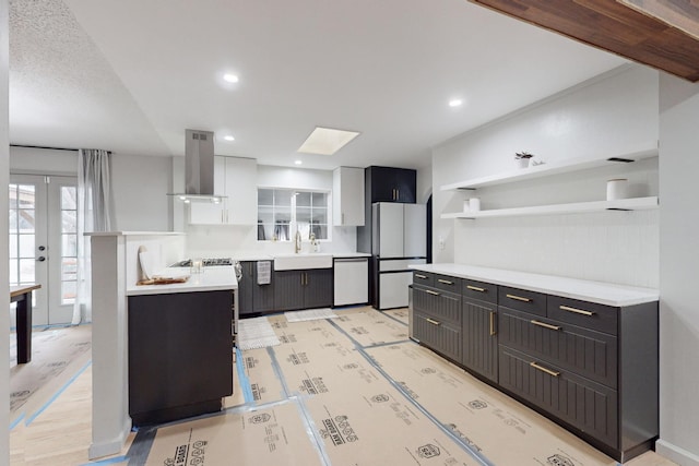 kitchen with dishwashing machine, white cabinets, white fridge, sink, and island range hood