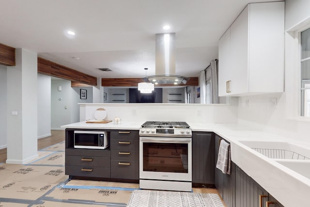 kitchen with dark brown cabinetry, white cabinets, decorative light fixtures, island range hood, and stainless steel range with gas cooktop