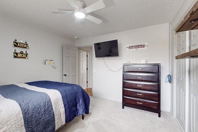 carpeted bedroom featuring ceiling fan, a textured ceiling, and crown molding