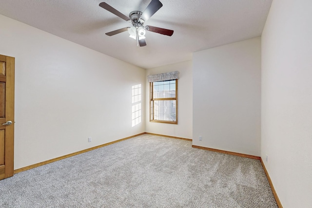 carpeted spare room featuring ceiling fan