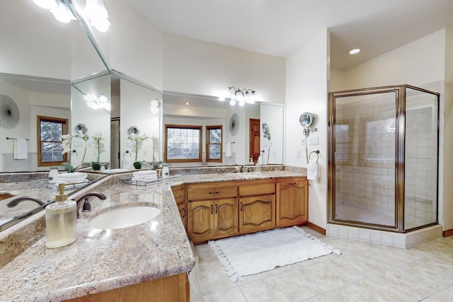 bathroom with an enclosed shower, vanity, and tile patterned flooring