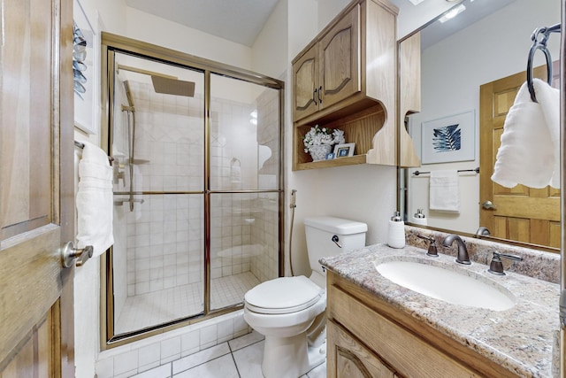 bathroom with toilet, tile patterned flooring, a shower with door, and vanity