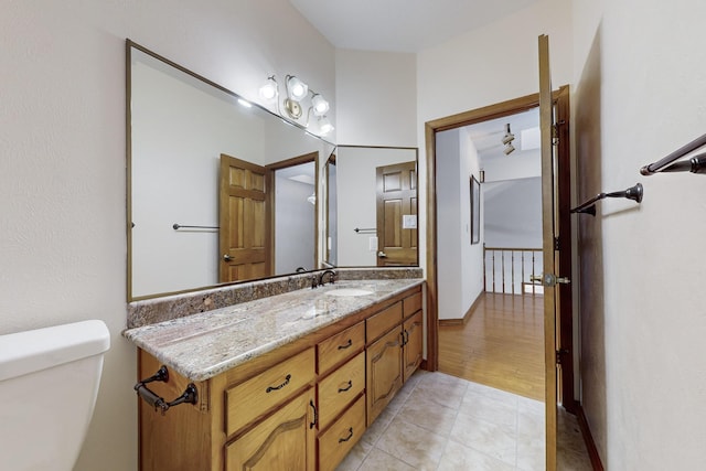 bathroom featuring toilet, tile patterned flooring, and vanity