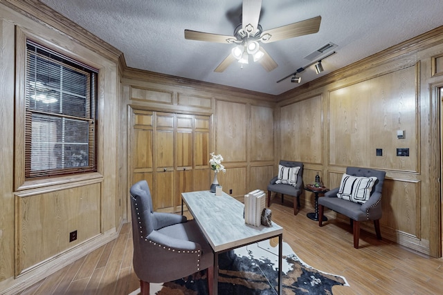 office with a textured ceiling, wood walls, and light hardwood / wood-style floors